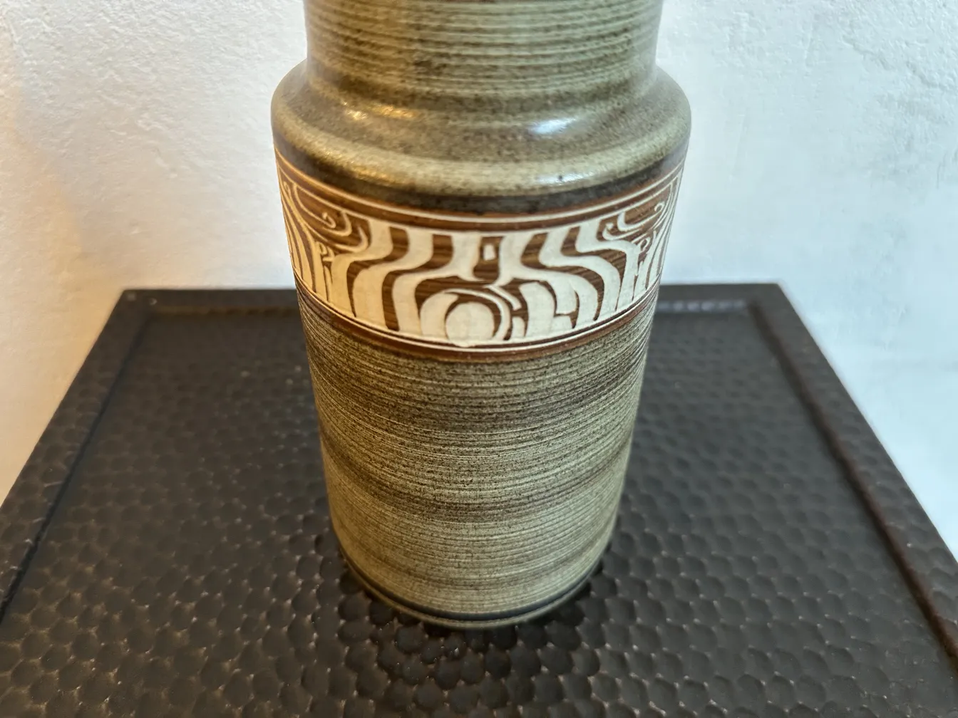 Vaso in ceramica antica con decorazione distintiva al centro.