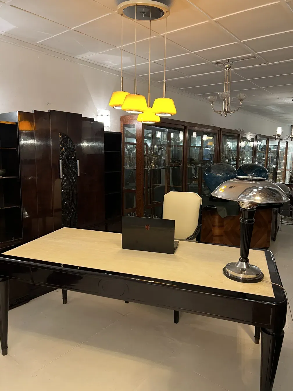 Escritorio antiguo nordiska kompaniet con lámpara y decoración en fondo.