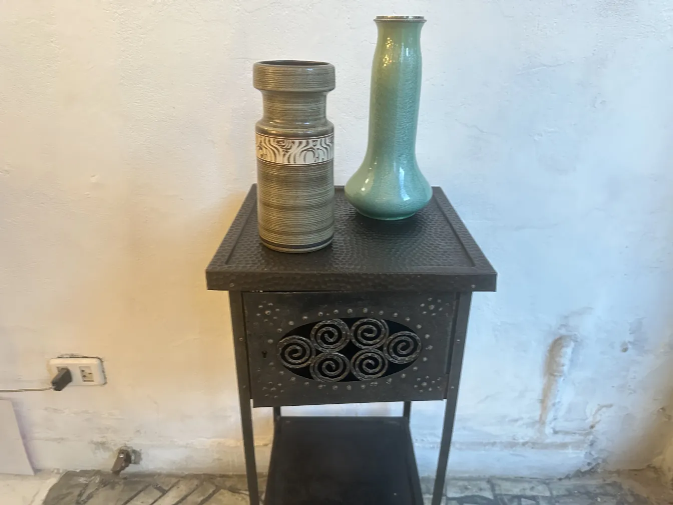 vase en céramique ancienne avec détails décoratifs sur une table patinée