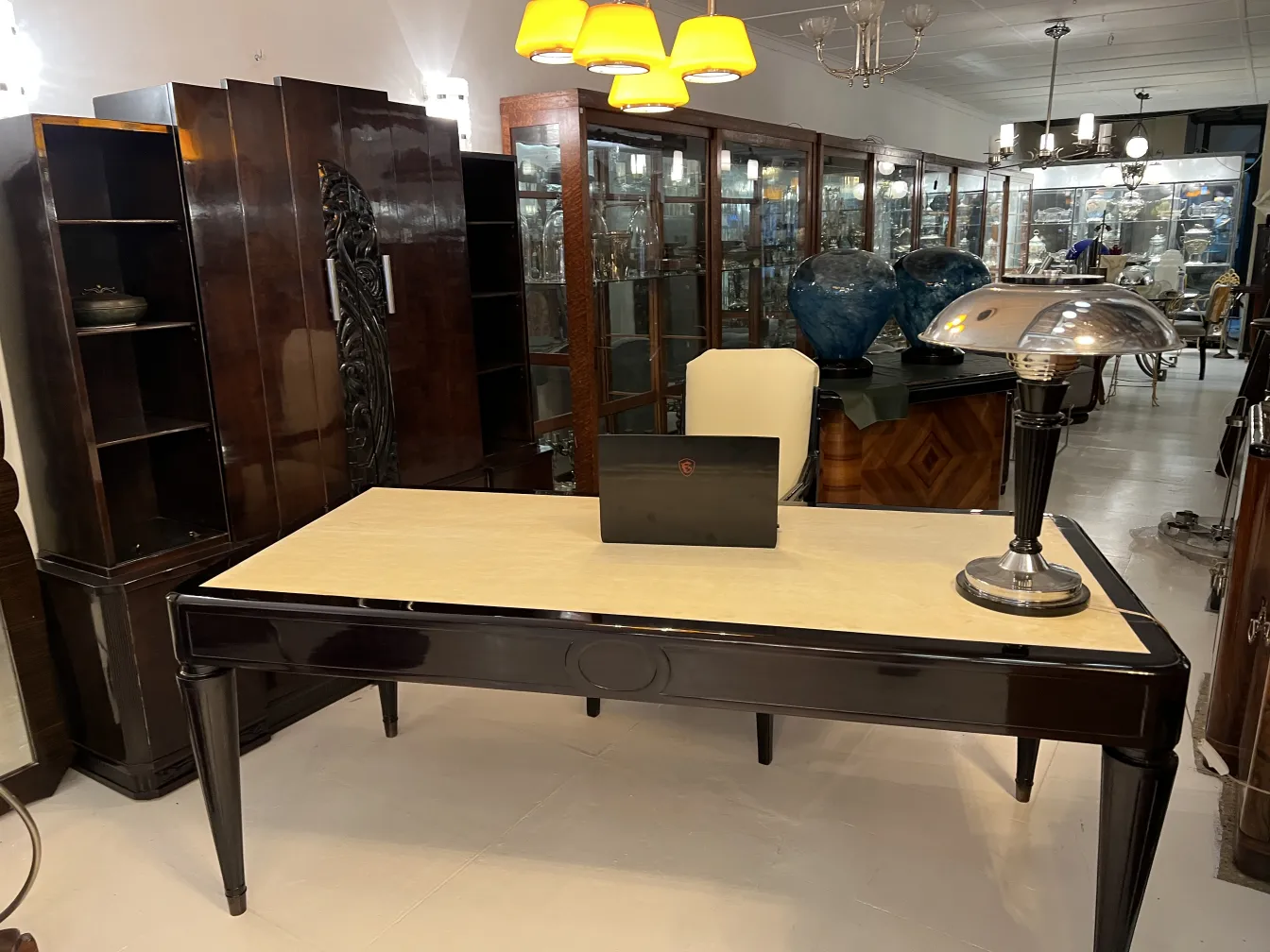 Antiker schreibtisch nordiska-kompaniet mit einzigartigem design in eleganter umgebung mit moderner lampe.