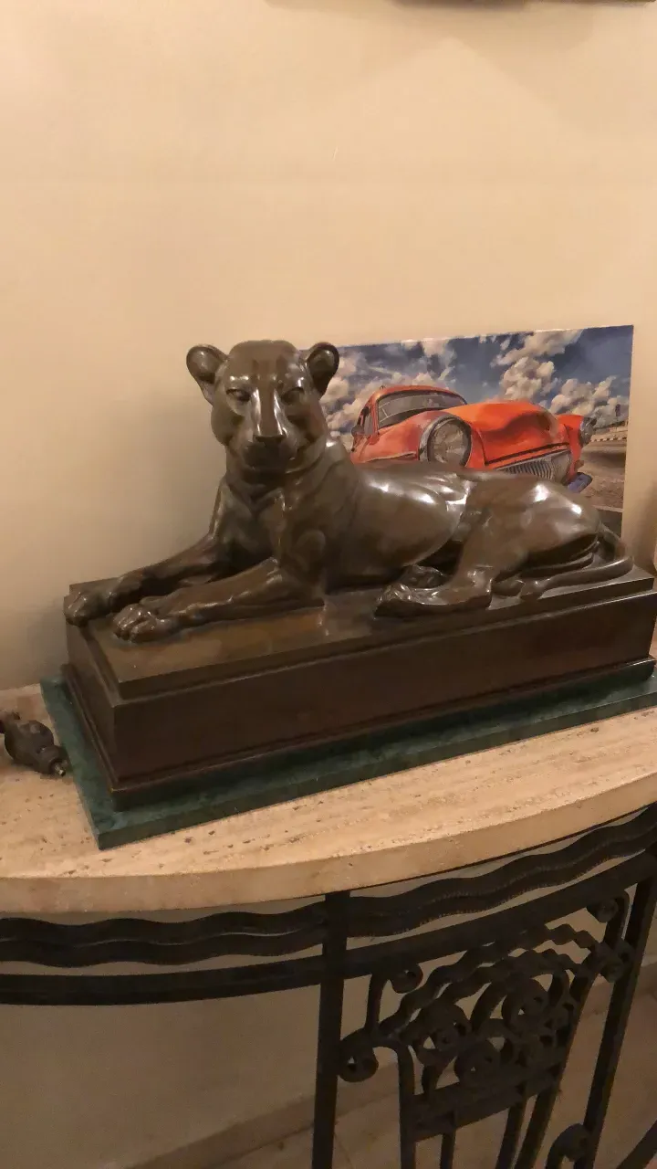 escultura antiga de leão descansando em pedestal