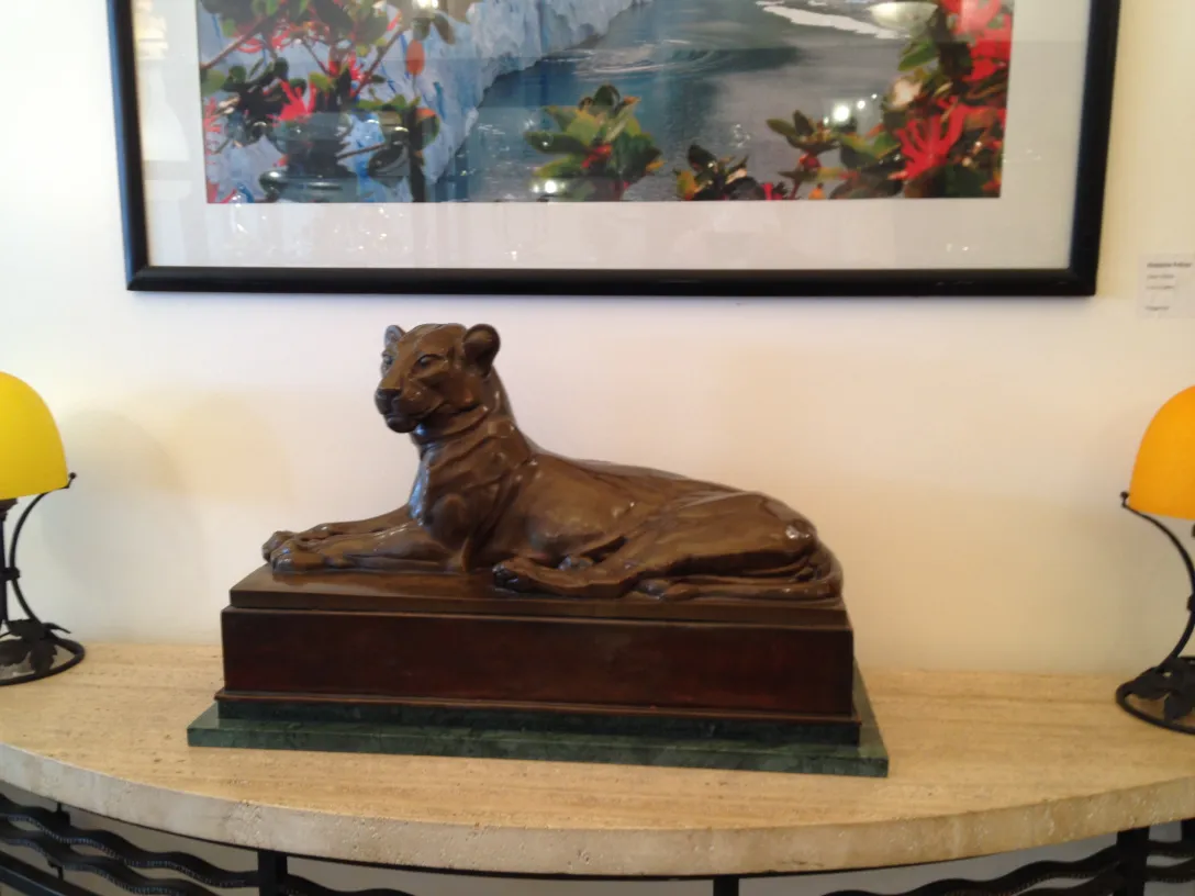 antique sculpture of a lioness on a decorative table