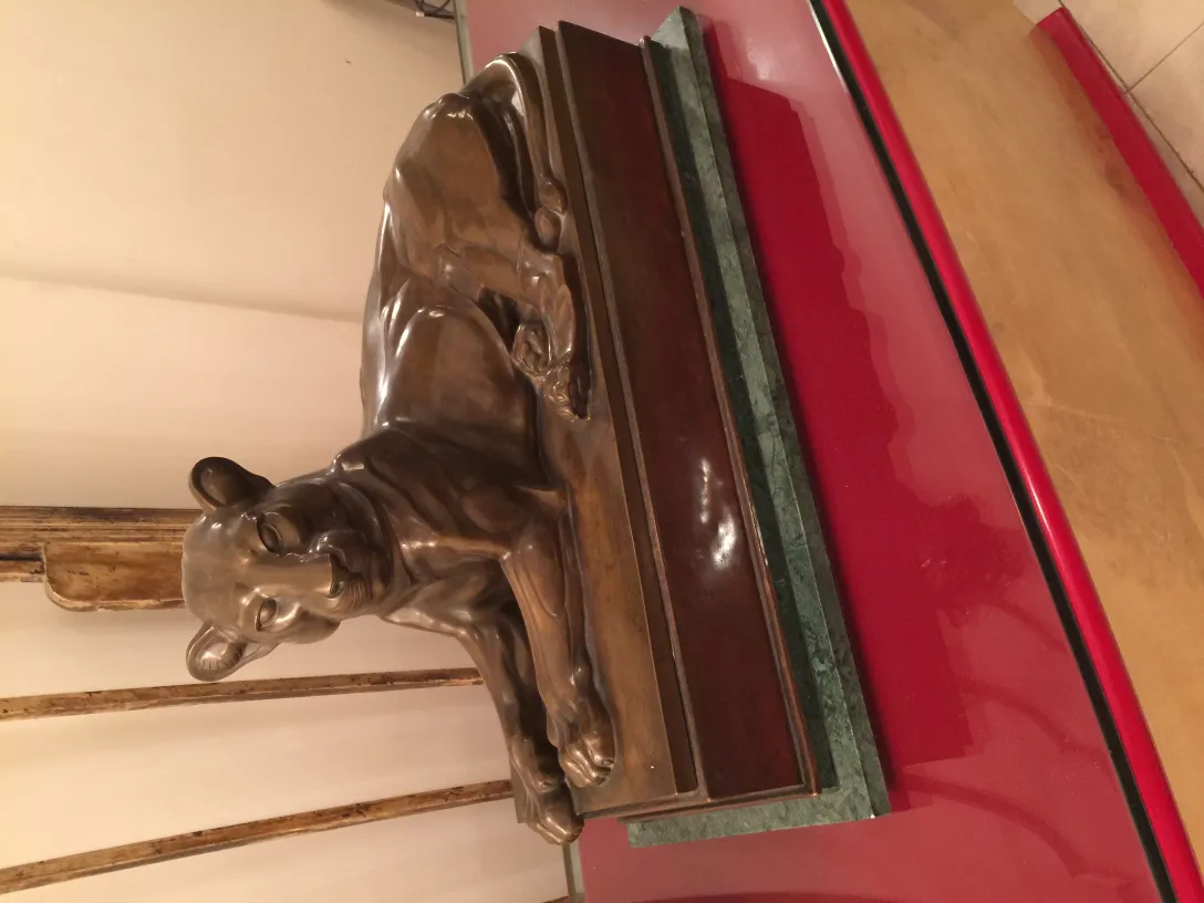 antica scultura di un gatto che riposa su una base