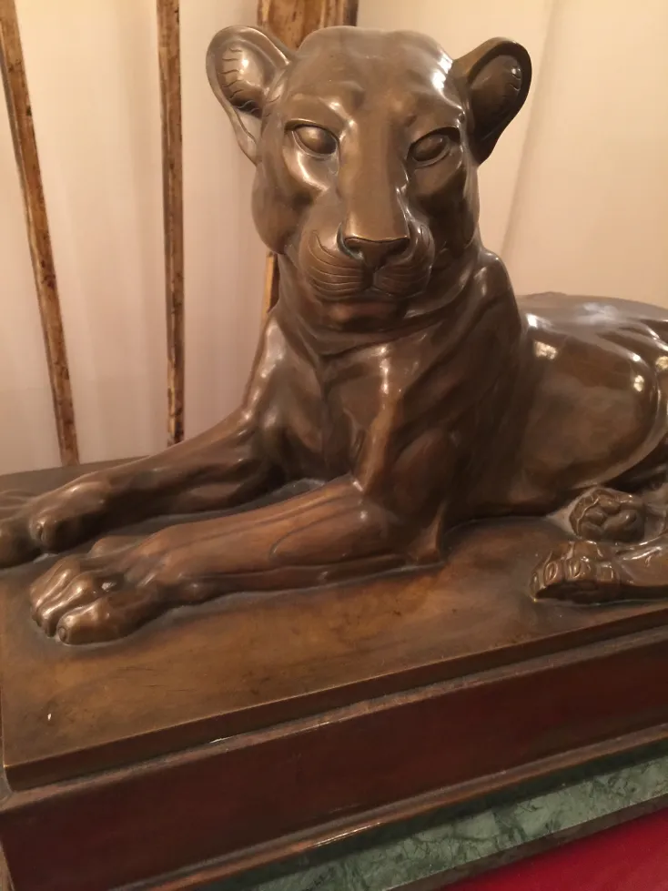 scultura antica di leone in riposo su una base