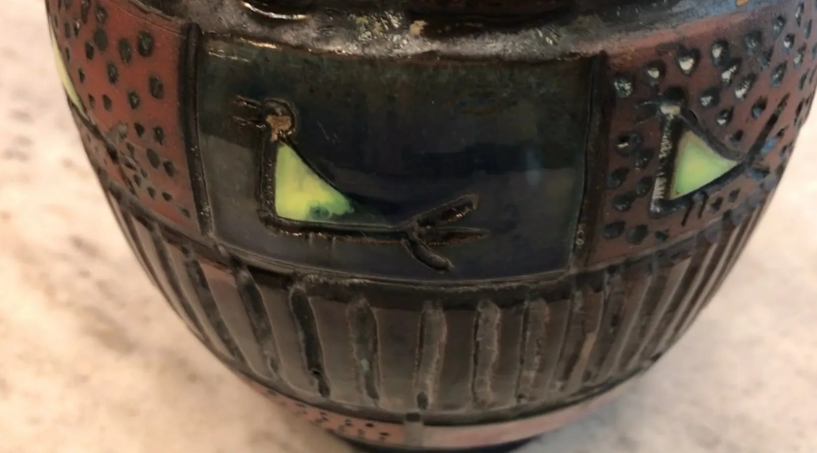 Ceramica antica con decorazione di animali, dettagli colorati e testurizzati.