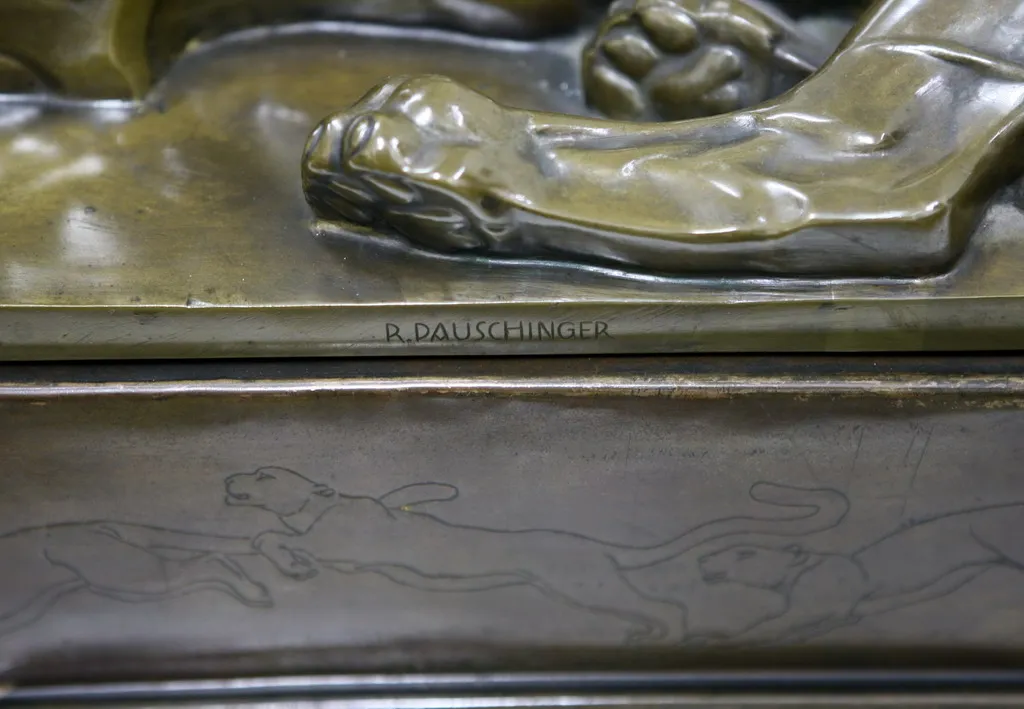 escultura antigua con detalles de animales y firma visible