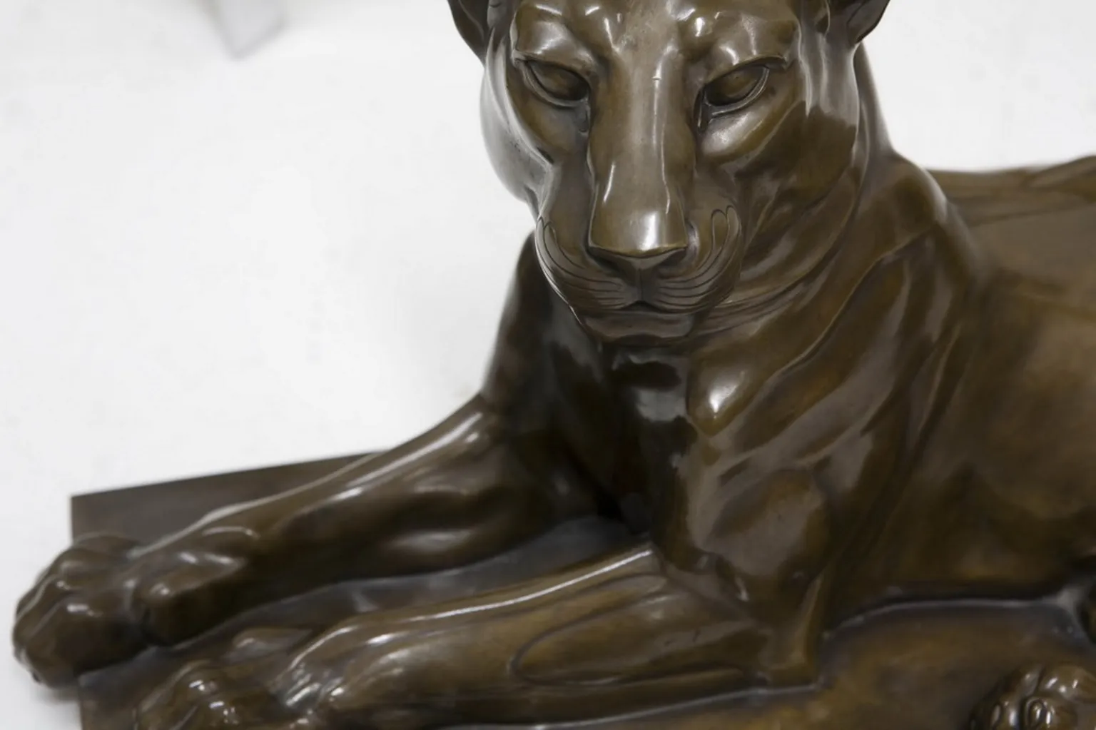 sculpture ancienne d'un lion en position détendue