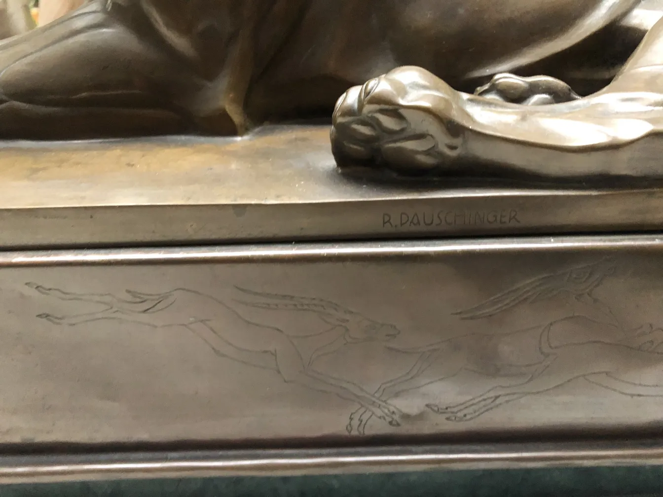 escultura antiga com textura detalhada e animais em movimento