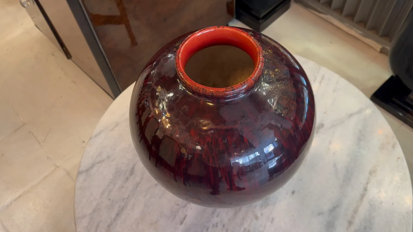Cerâmica antiga boch frères keramis com forma redonda e cor escura, decorada em um ambiente elegante.