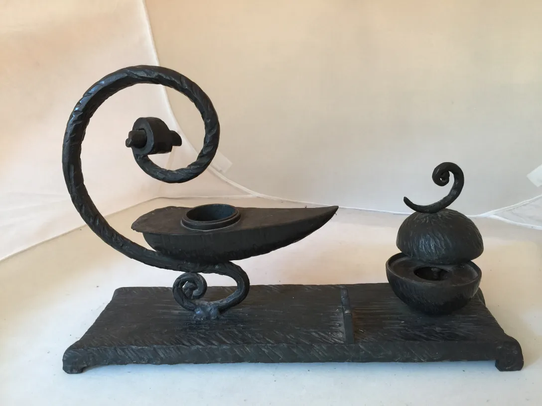 escultura antiga com formas curvas e detalhes decorativos em um ambiente neutro