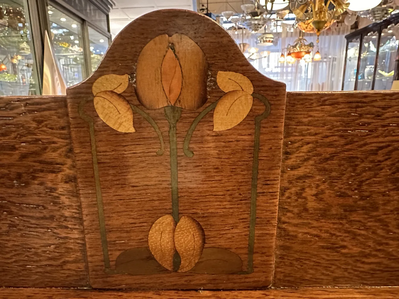 Antique desk with floral design on the top, background with other antiques.