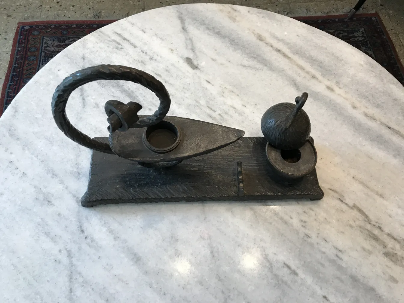 scultura antica con forme decorative e dettagli complessi, sfondo neutro