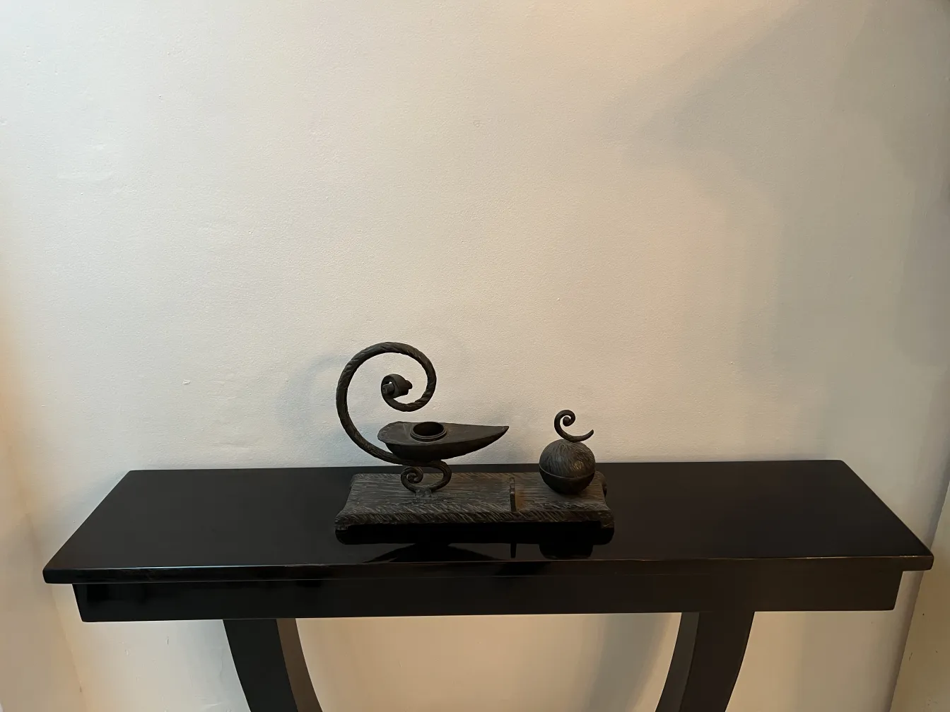 escultura antiga em uma mesa preta com luz suave