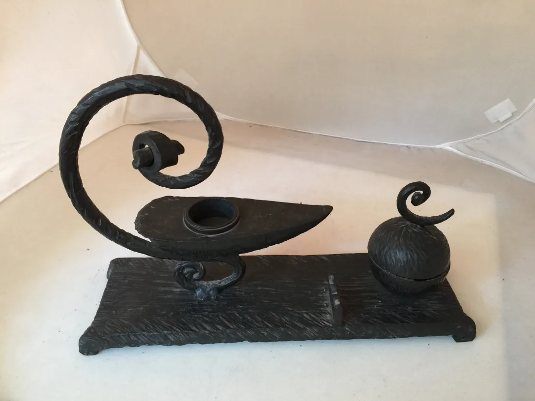 scultura antica decorativa con dettagli a spirale e base piatta