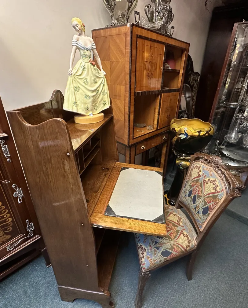 Escritorio antiguo con estante, decorado y elegante, junto a una figurita