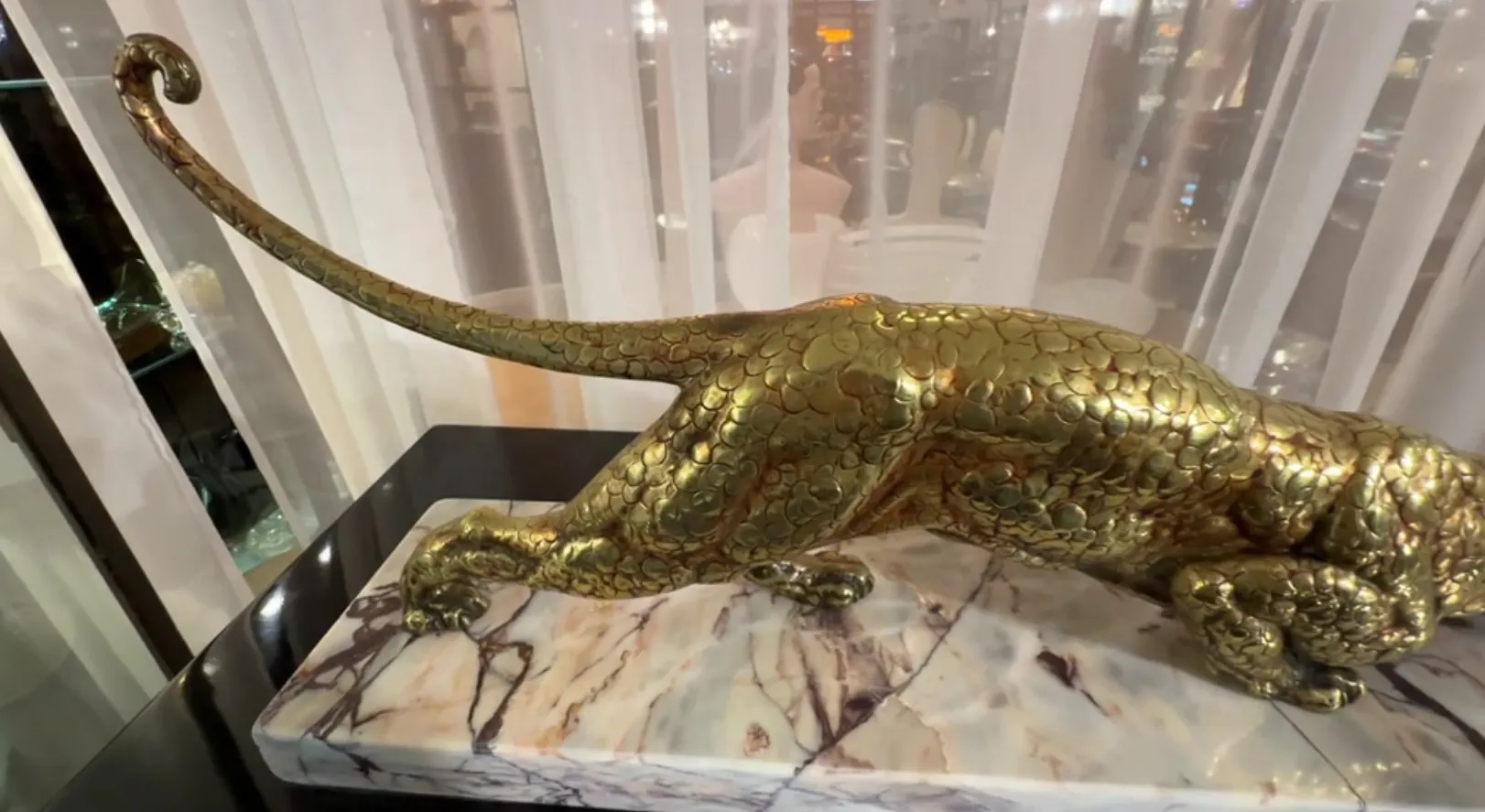 antike goldene Felinskulptur auf marmorierter Basis, elegant und raffiniert