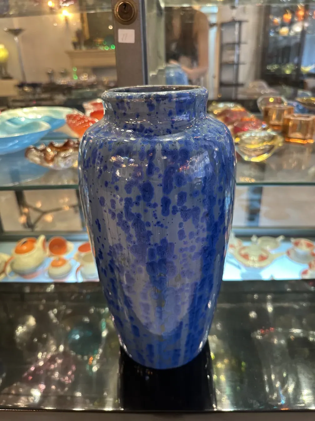 Antigo vaso de cerâmica com padrão azul, ambiente elegante.