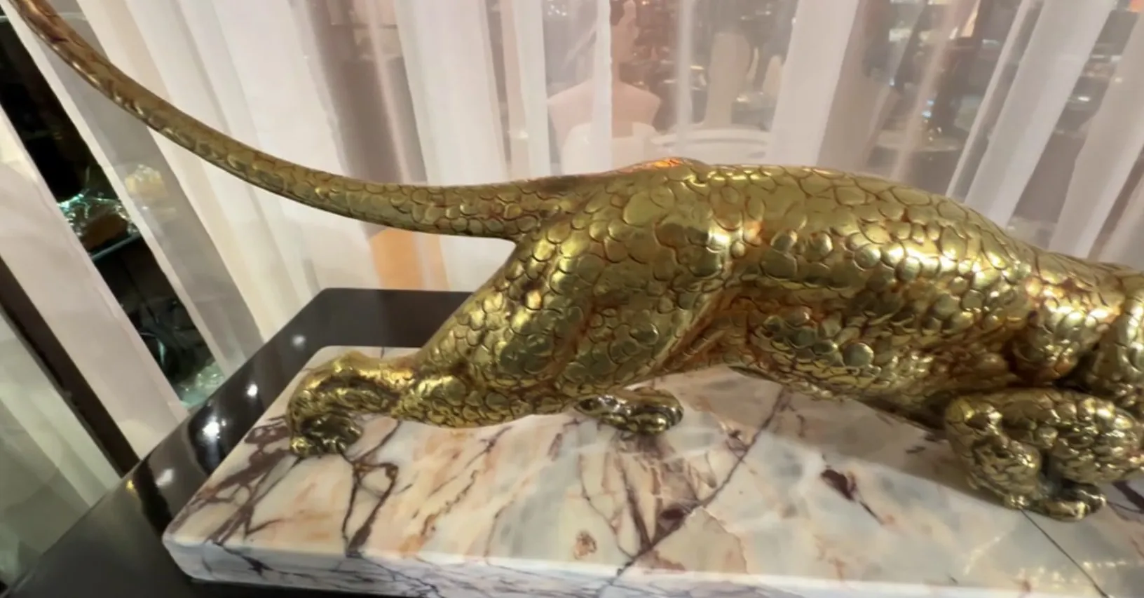 sculpture ancienne d'animal avec détails dorés et base élégante