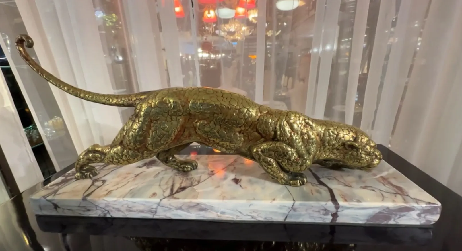 antique sculpture of a feline on decorative base