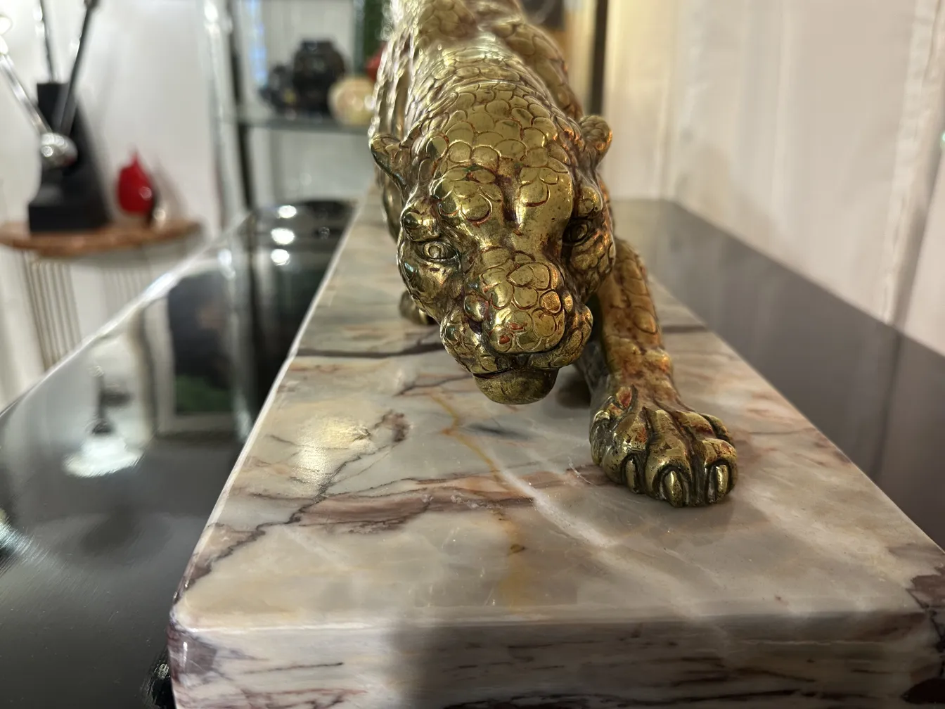 escultura de pantera com detalhes dourados em base de mármore