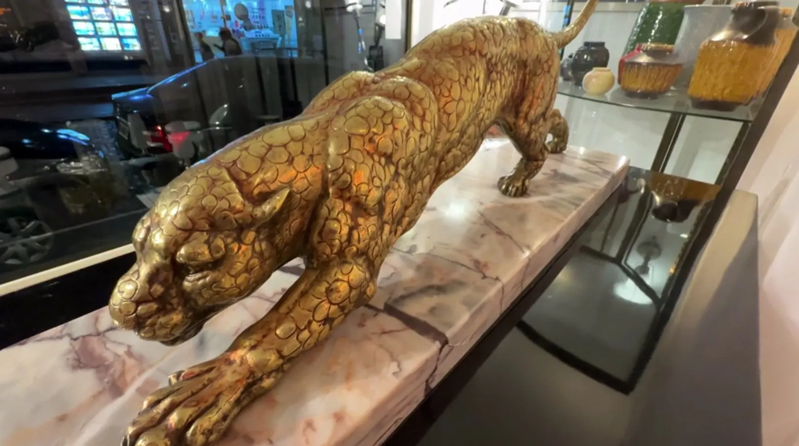 escultura antigua de felino dorado en una mesa elegante