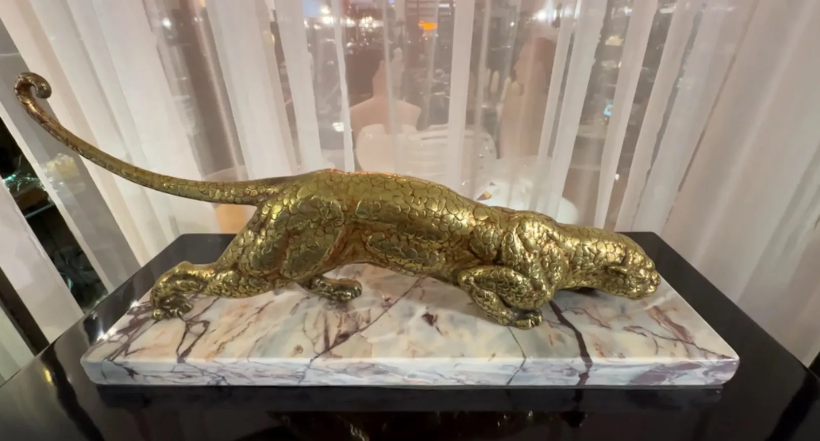 scultura di un gatto su una base di marmo, posa elegante