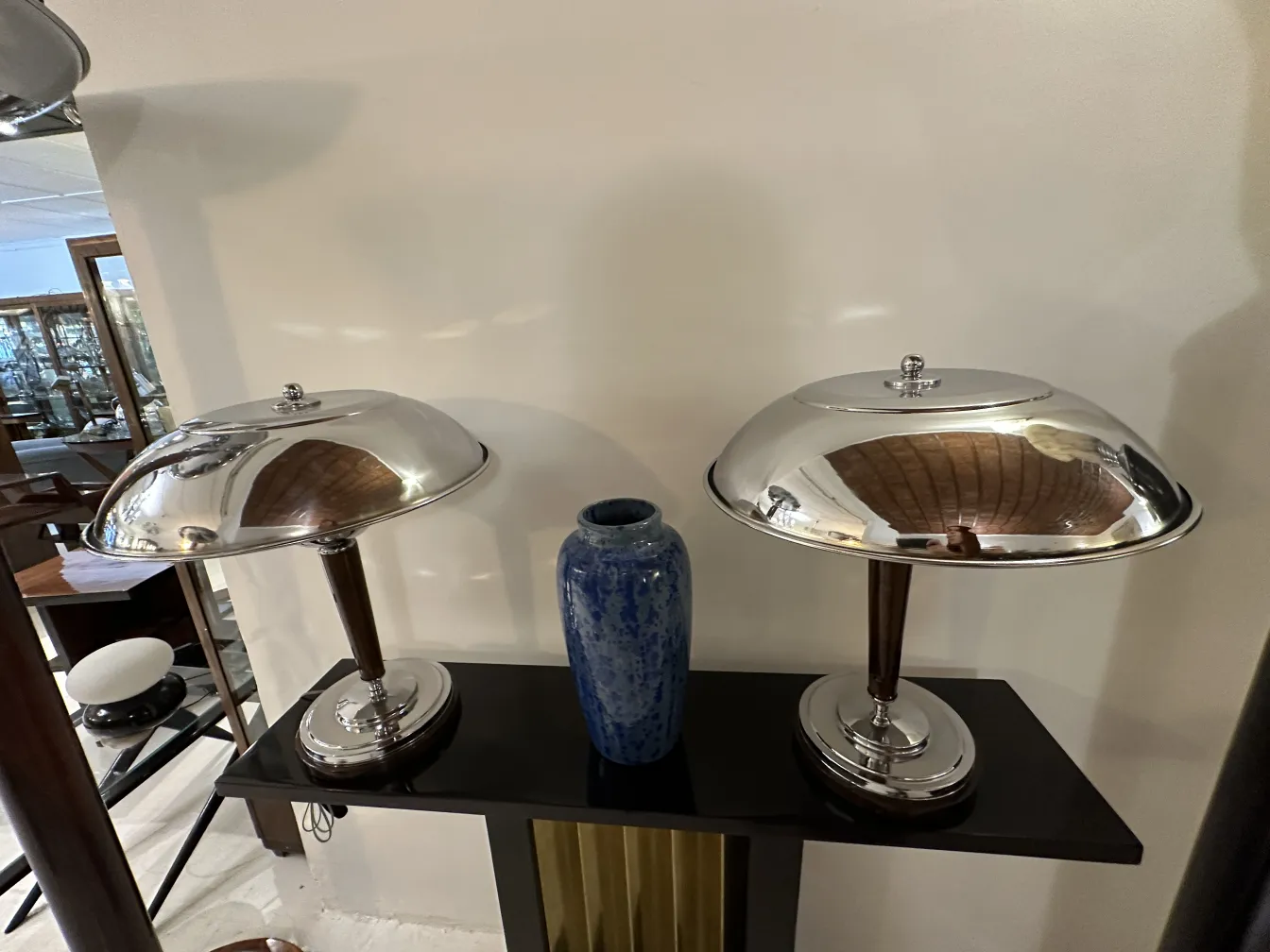 Due lampade con base metallica e un vaso in ceramica blu in un contesto d'antiquariato.