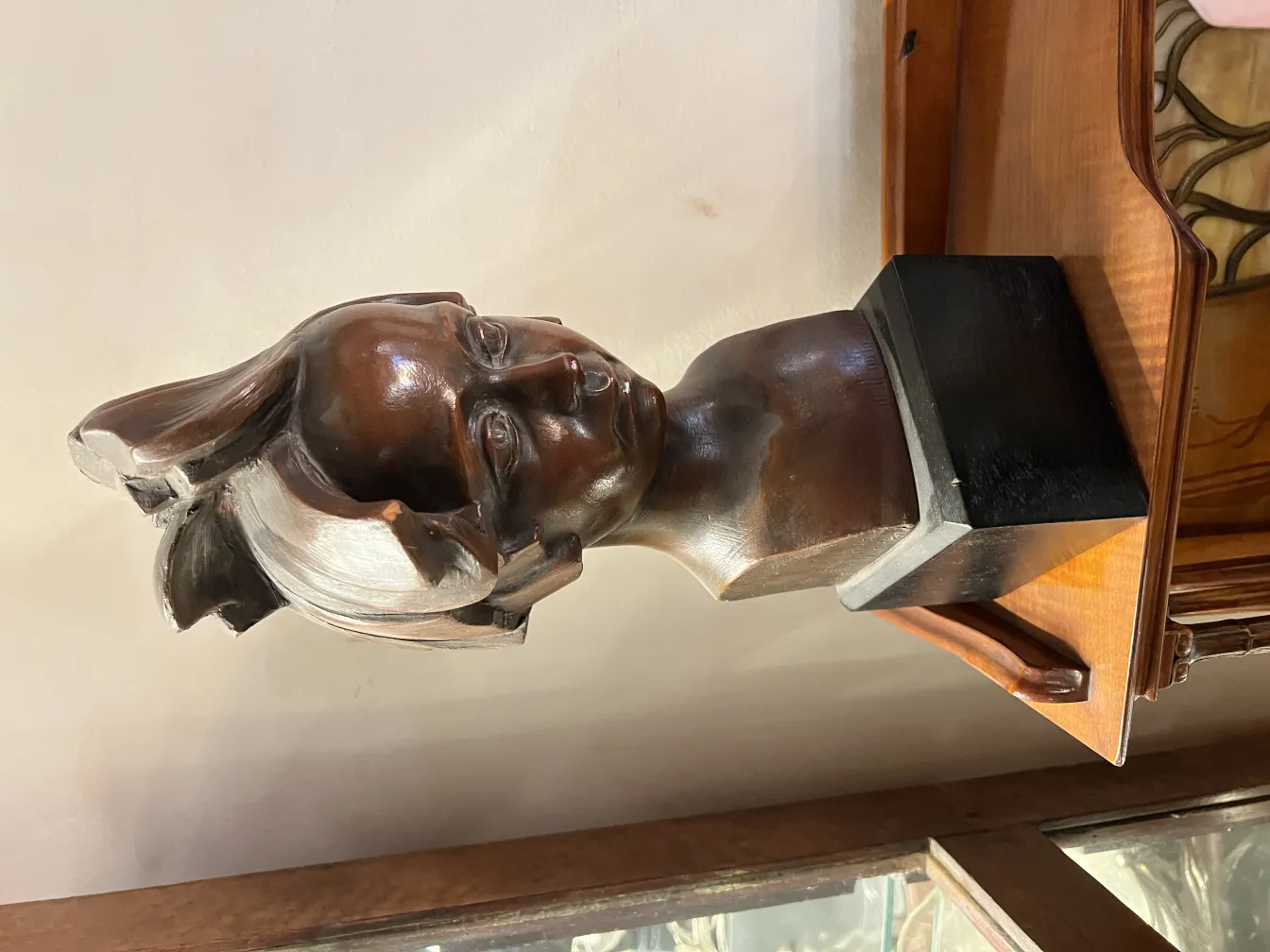 escultura antigua de un busto con cabello ondulado