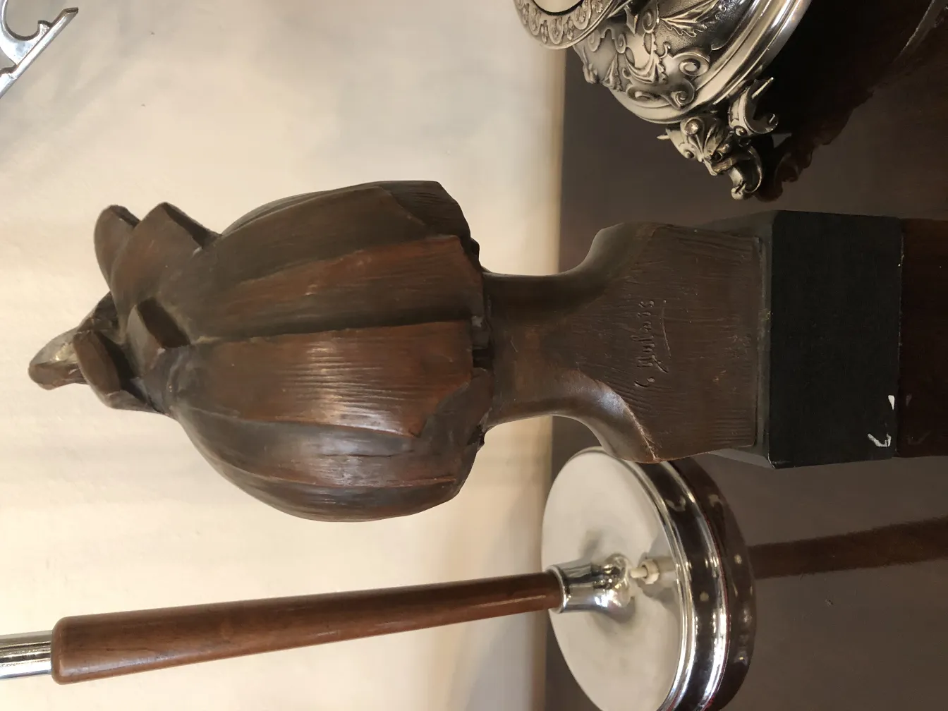 escultura antiga com detalhes na cabeça e base preta