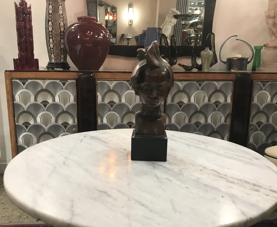 scultura antica di una testa su un tavolo