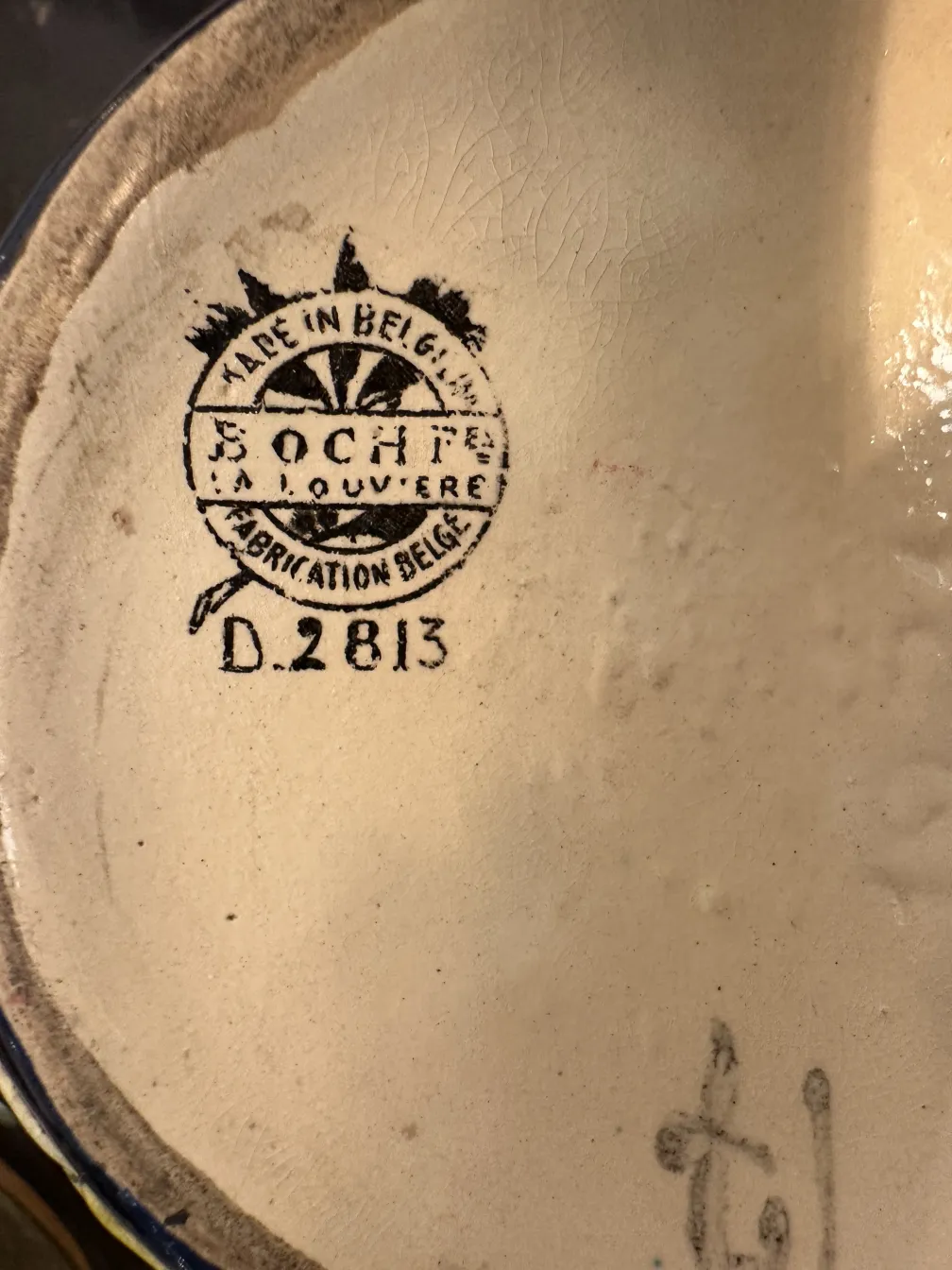 Antigua cerámica belga con marca de fabricación visible.