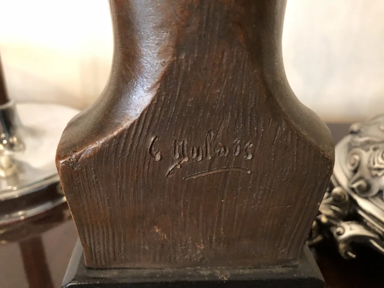 escultura antiga com detalhes gravados e fundo decorativo