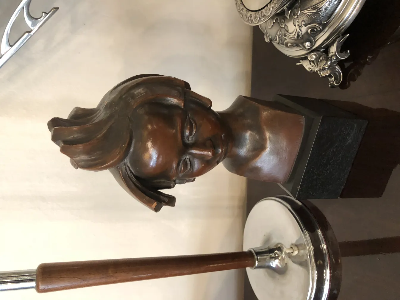 Antike Skulptur eines Kopfes mit ausdrucksvollen Details, neutraler Hintergrund.