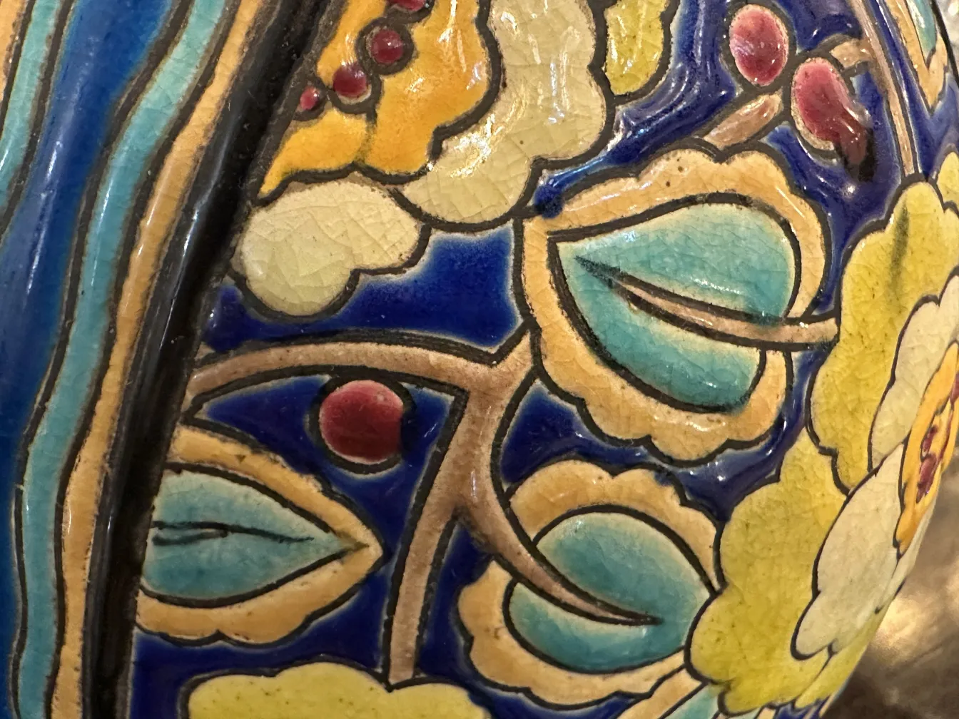 Antike Keramik von Boch Frères Keramis mit bunten Malereien, floralen Details und lebhaften Farben auf blauem Hintergrund.