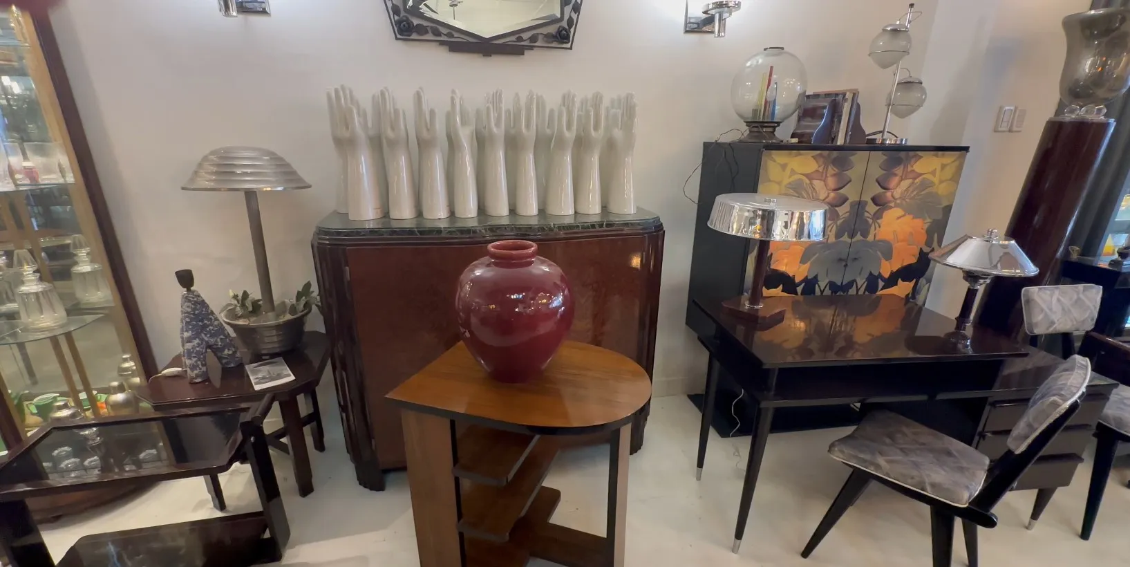 Antica ceramica in tonalità rosse su tavolo di legno in un ambiente antico.