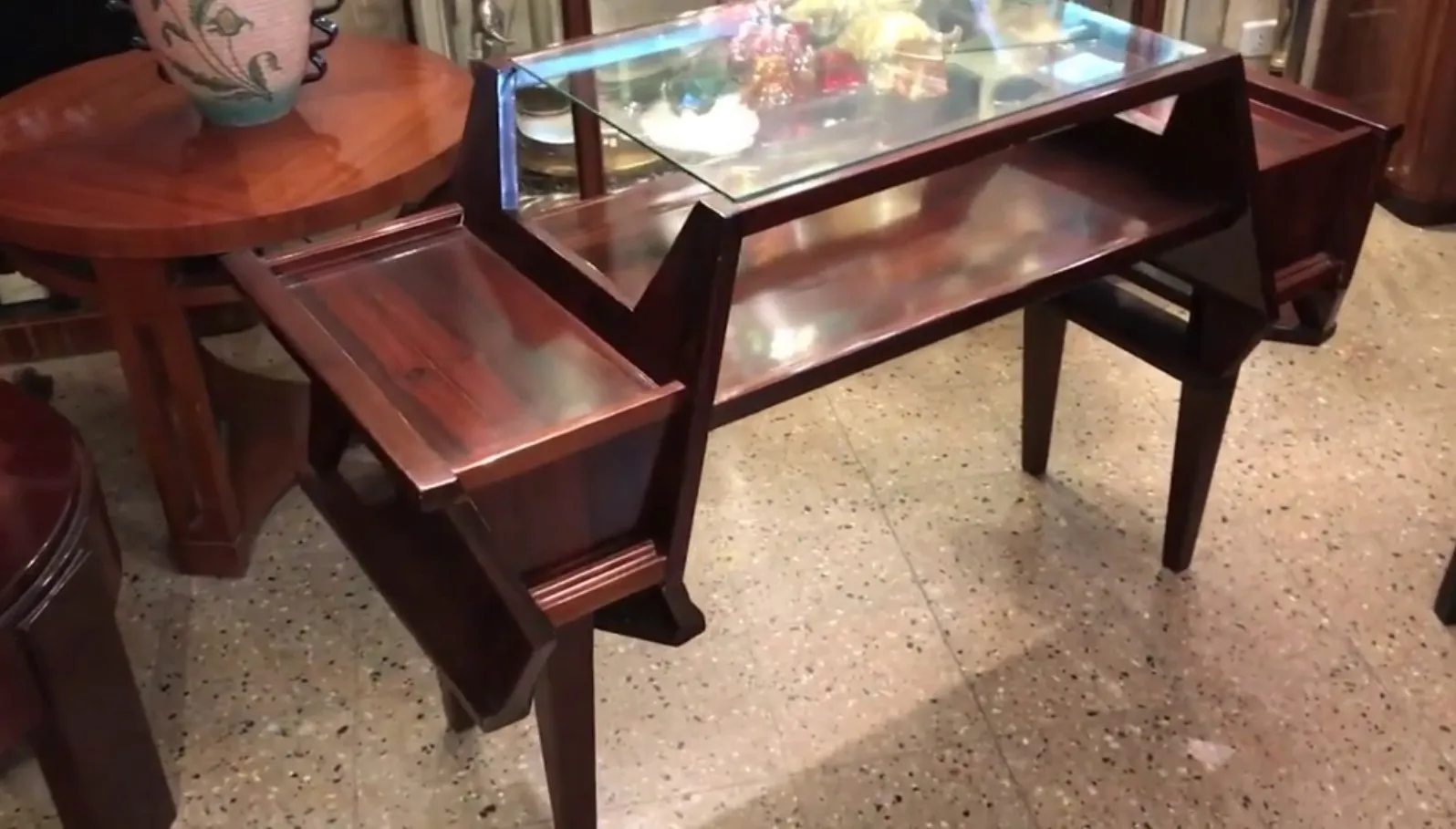 bureau ancien avec une finition brillante, décoré de manière élaborée et entouré de meubles classiques