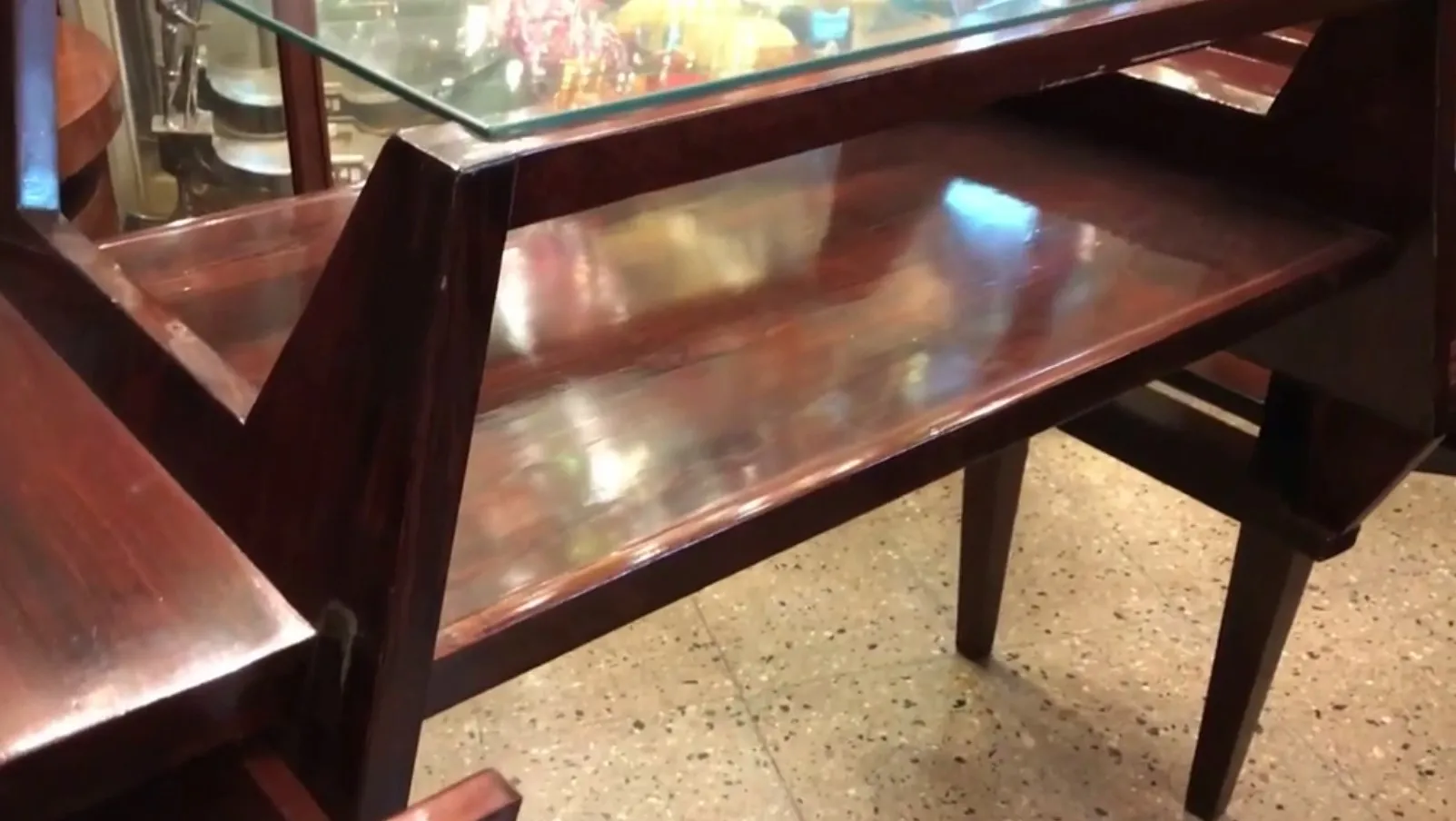 Escritorio antiguo con superficie de cristal, detalles elegantes y ambiente acogedor.