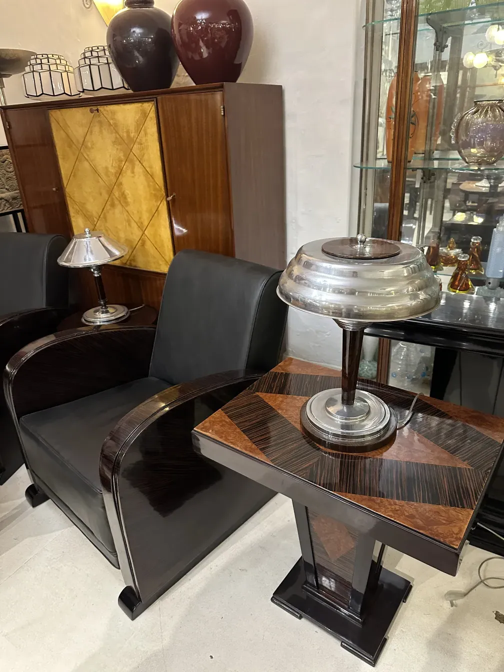 Tavolino laterale con finiture in ceramica antica e lampada, ambiente elegante.