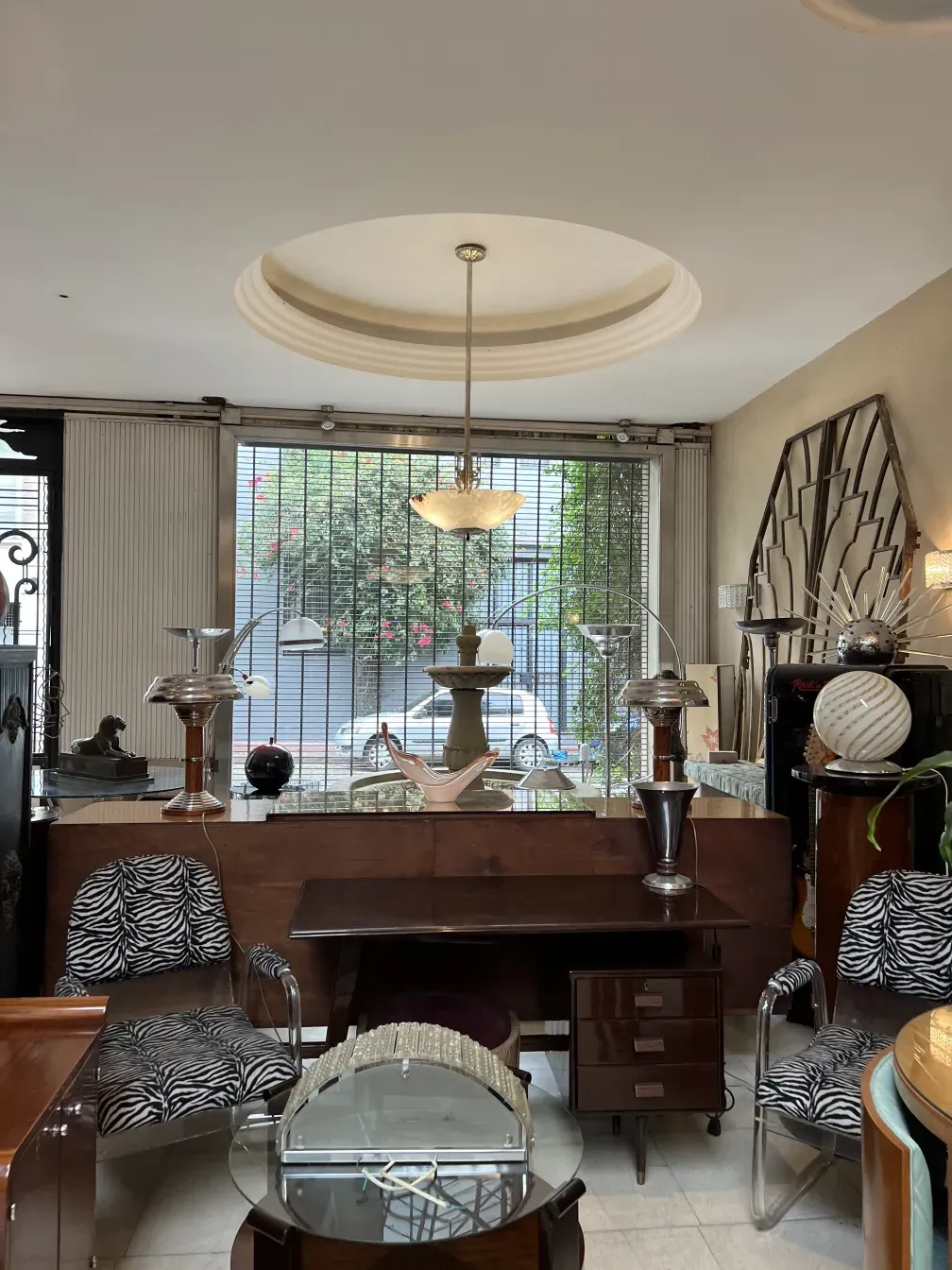 escritorio antigo com lâmpada e cadeiras de designer