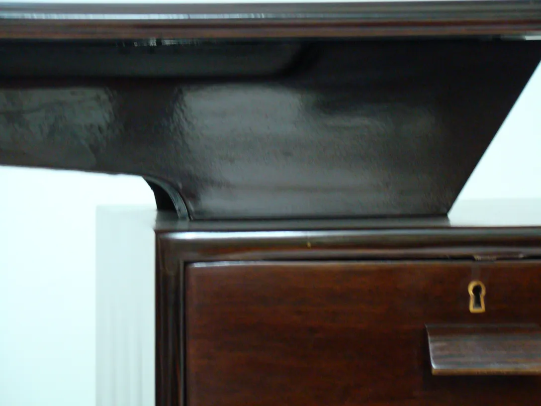 洗練されたデザインと磨き上げられた仕上げを持つ古い木製デスクのクローズアップ、余分なものはありません。