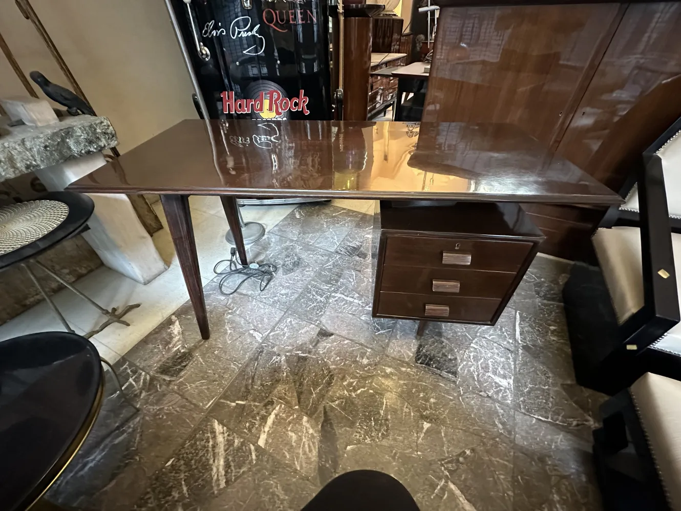 古董书桌，细长的桌腿和抽屉，背景是其他家具