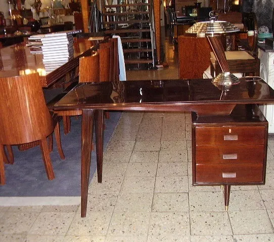 escritorio antiguo de madera con dos cajones y lámpara en un ambiente acogedor