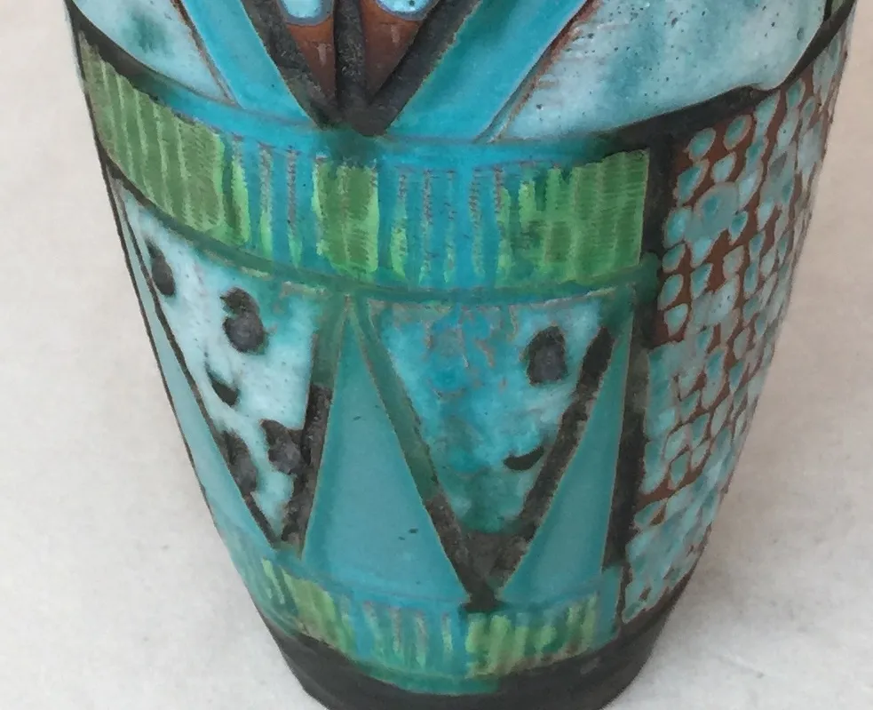 Cerâmica antiga em tons de azul e verde com desenhos abstratos.