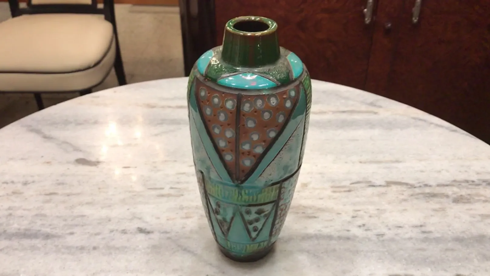 Vaso decorativo ceramico antico colorato con motivi geometrici.