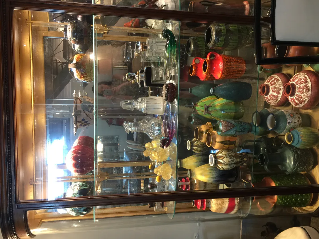 Vitrine mit antiker dekorativer Keramik in verschiedenen Farben und Formen