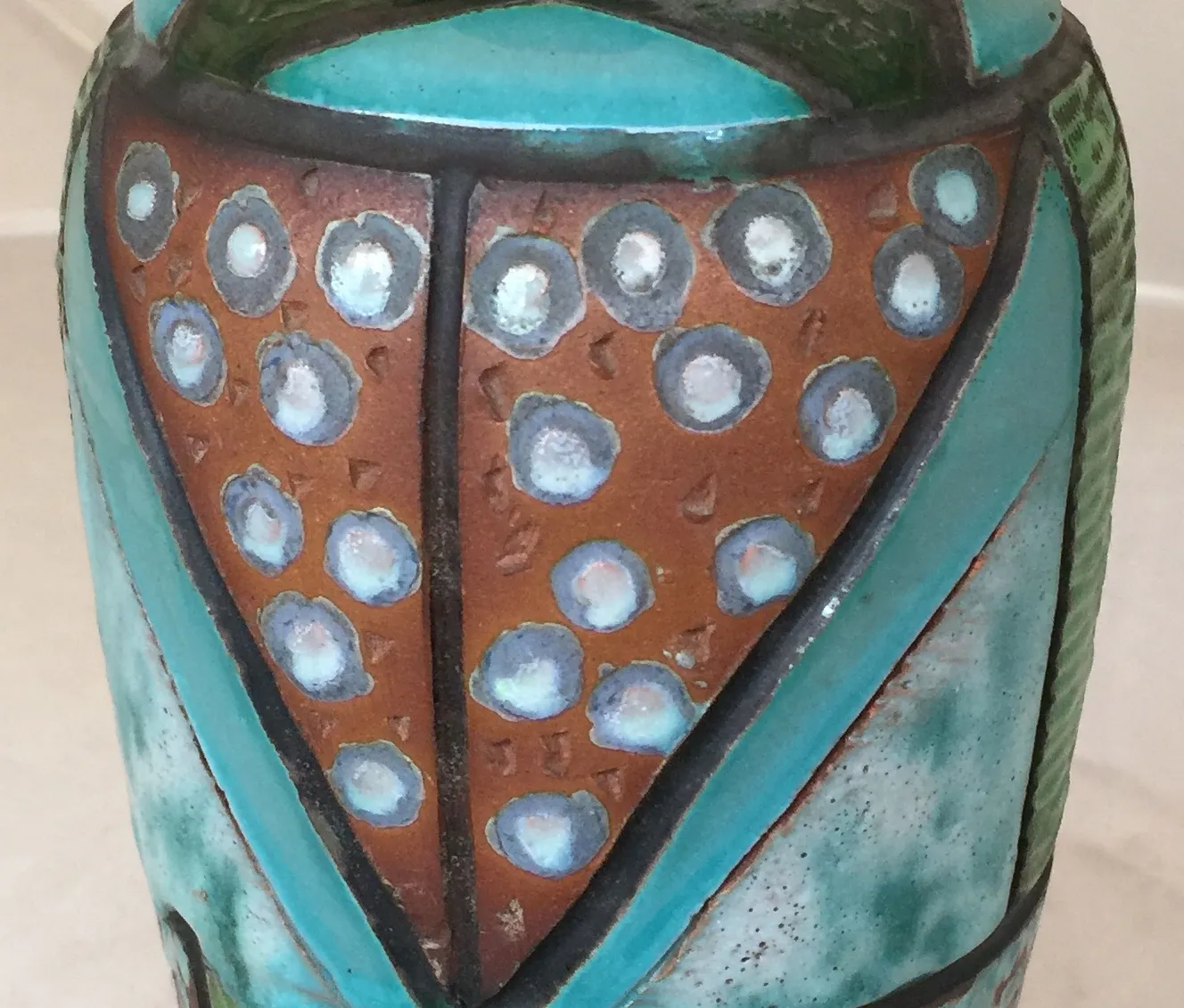 Vase en céramique ancienne avec des motifs décoratifs colorés.