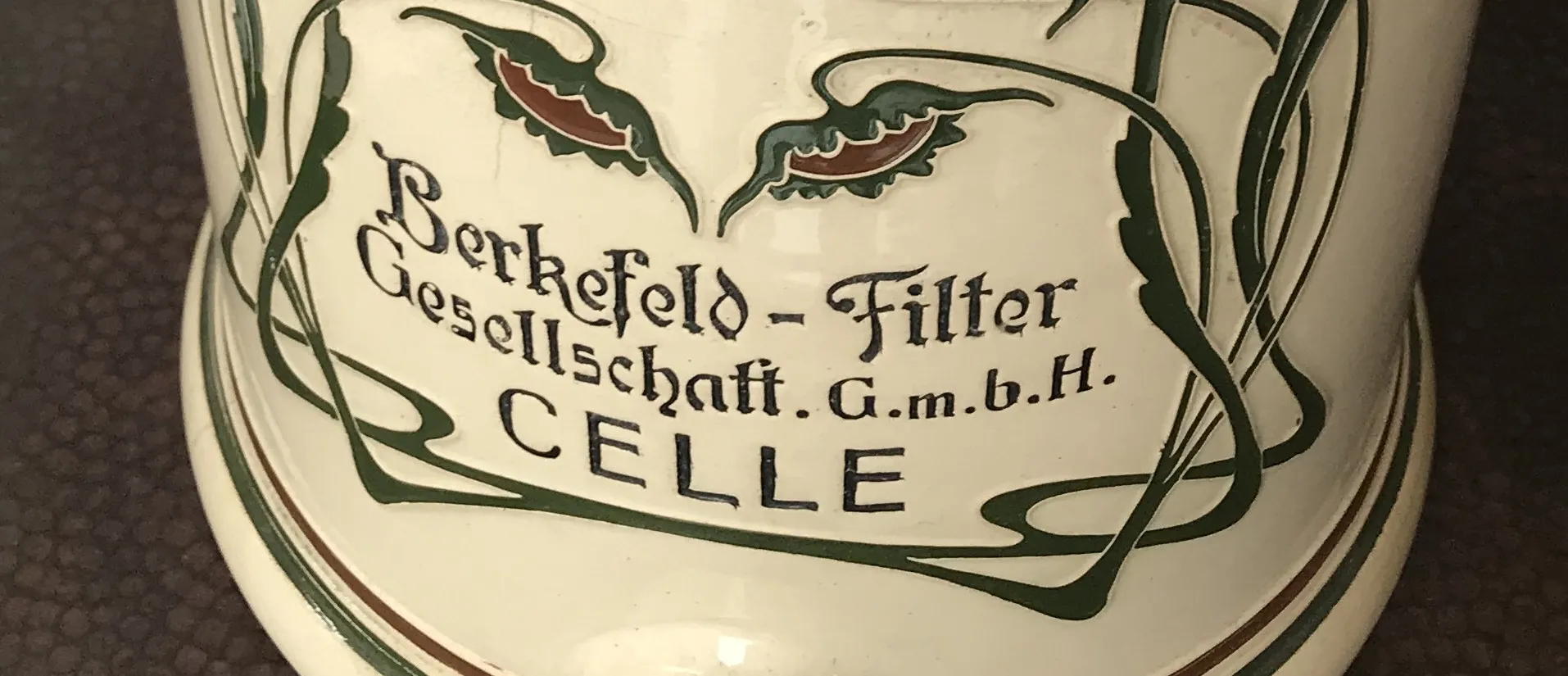 Antike Berkefeld-Keramik mit floraler Dekoration in Grün und Rot.