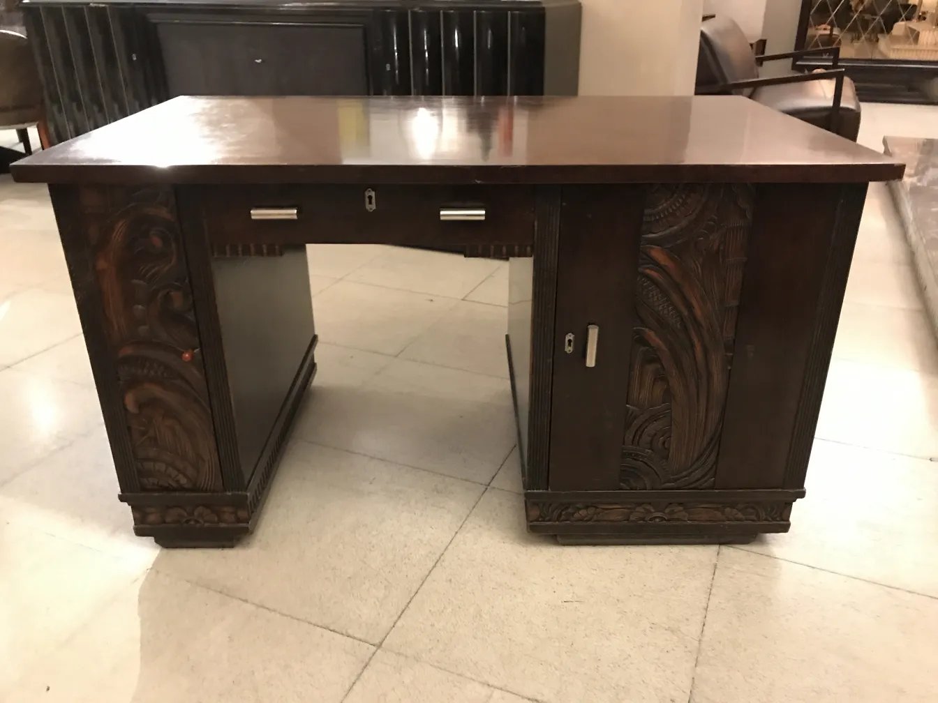 Scrivania antica con dettagli scolpiti, ambiente elegante.