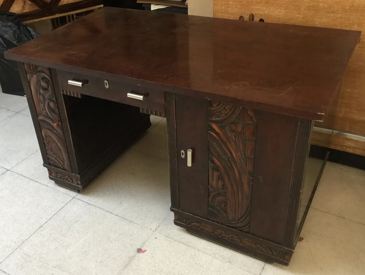 Antique wooden desk with detailed carving and storage space.
