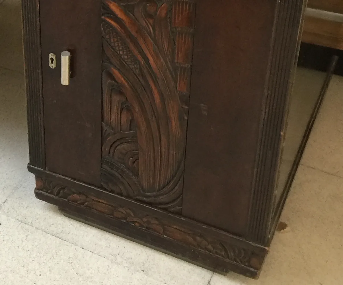 Vista de un antiguo escritorio con tallado artístico y detalles ornamentales, ideal para decoración clásica.